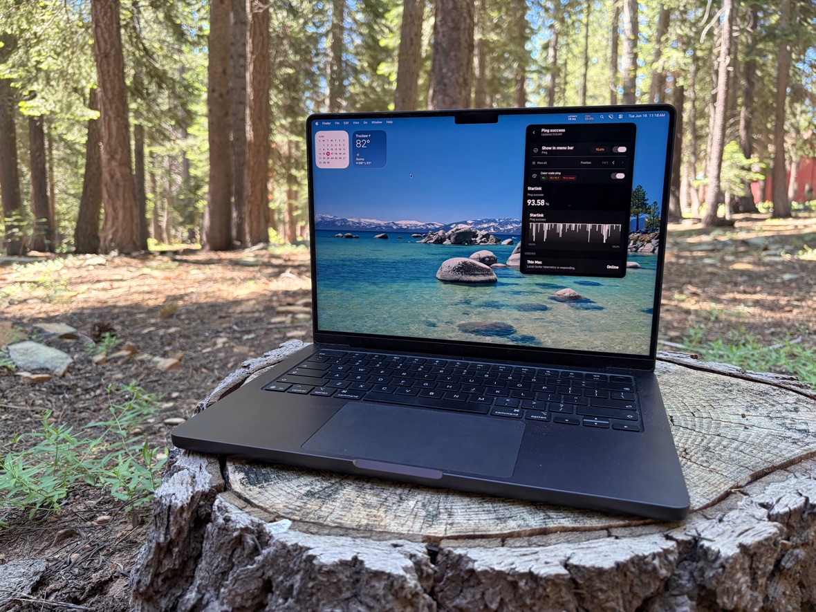 MacBook running StarBar on a tree stump in a forest